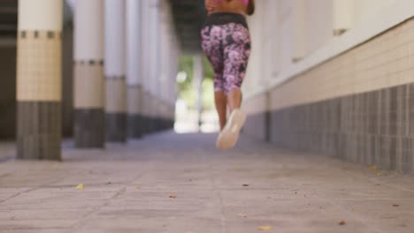 vista trasera de una mujer afroamericana corriendo en el corredor