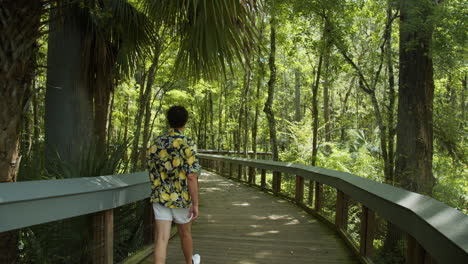 Viajero-Masculino-Con-Camisa-De-Flores-De-Colores-Caminando-Por-El-Sendero-En-Silver-Springs-En-Florida,-EE.UU.