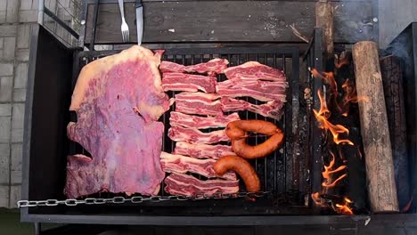 vista vertical de una barbacoa negra con carne cocinada al fuego en un día soleado