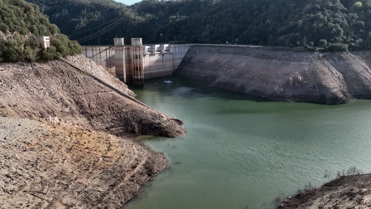 Aerial flying over Ter River towards Sau reservoir dam, low water level, Catalonia