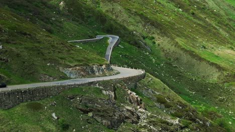 aerial drone view of cars driving on furka pass winding road in switzerland