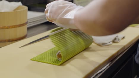 male sushi chef prepping sushi at a restaurant in slow motion close up