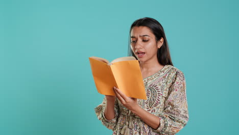 Cheerful-woman-smiling-while-enjoying-reading-activity,-holding-book