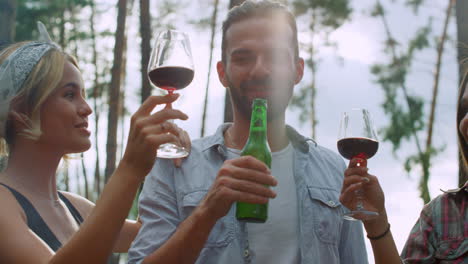 happy friends clinking glasses outdoors. fellows drinking alcohol outside