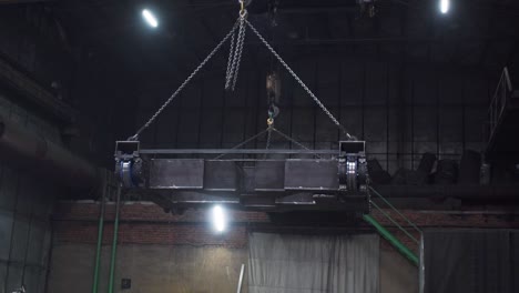 industrial machinery being lifted by a crane in a factory