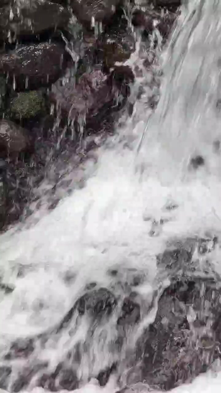 Piccola cascata che scende su rocce scure