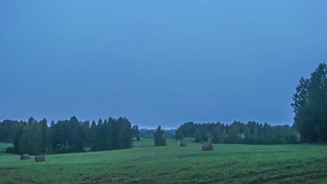 cloud timelapse shot of blue cloudy sky over picturesque grass meadow surrounded by trees at daytime