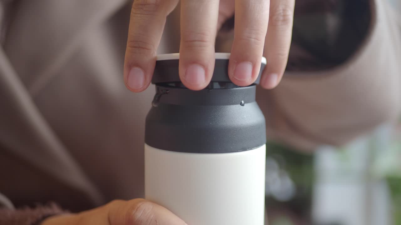 Woman's Hand Opening a Modern Reusable Bottle