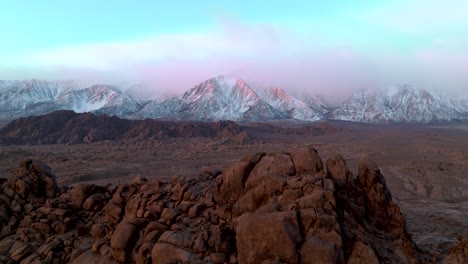Clouds cover the snowy peaks of the Sierra Mountains from the Alabama Hills