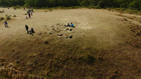 Panoramic-drone-shot-of-people-sitting-and-chilling-in-a-national-park