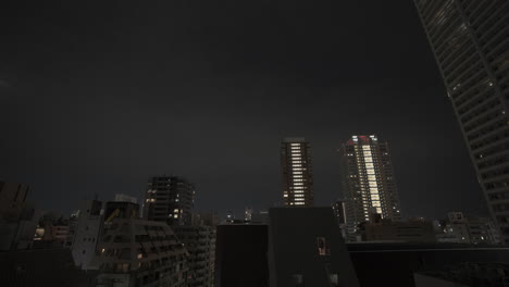 Timelapse-of-tall-buildings-in-Hong-Kong-at-night,-visible-moonlight-too