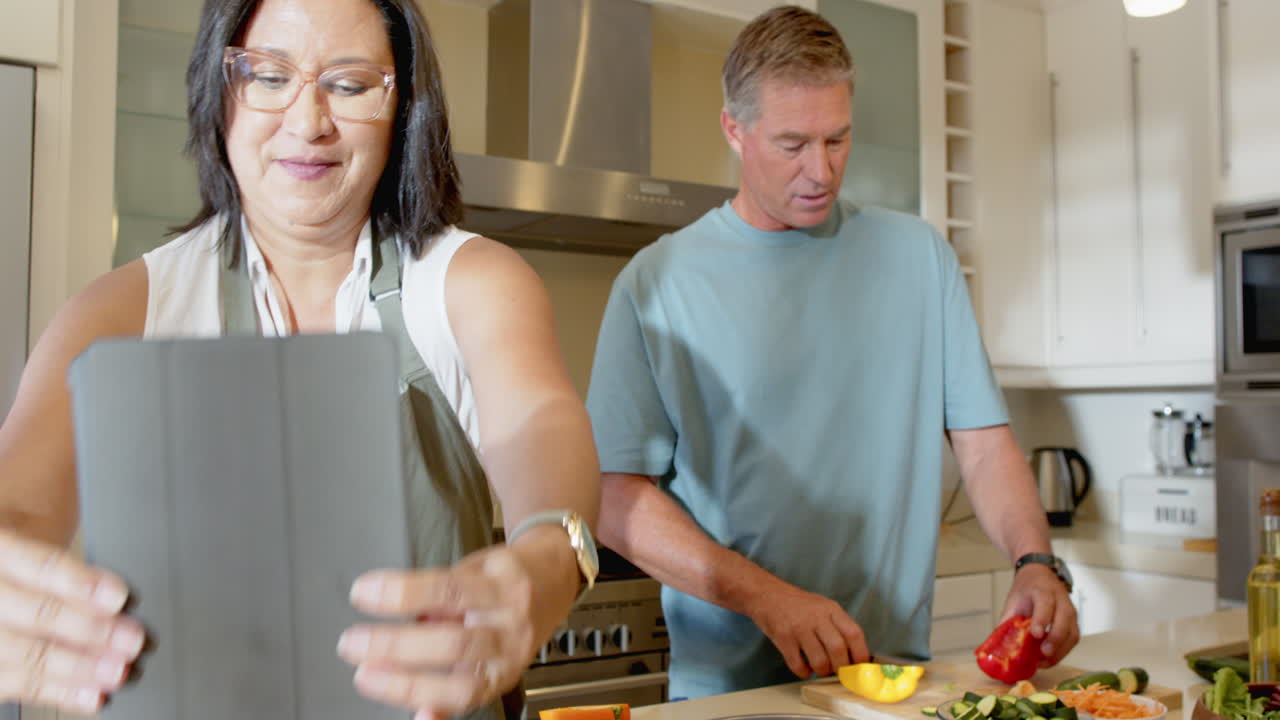 Preparing fresh vegetables, senior diverse couple cooking together in modern kitchen, at home