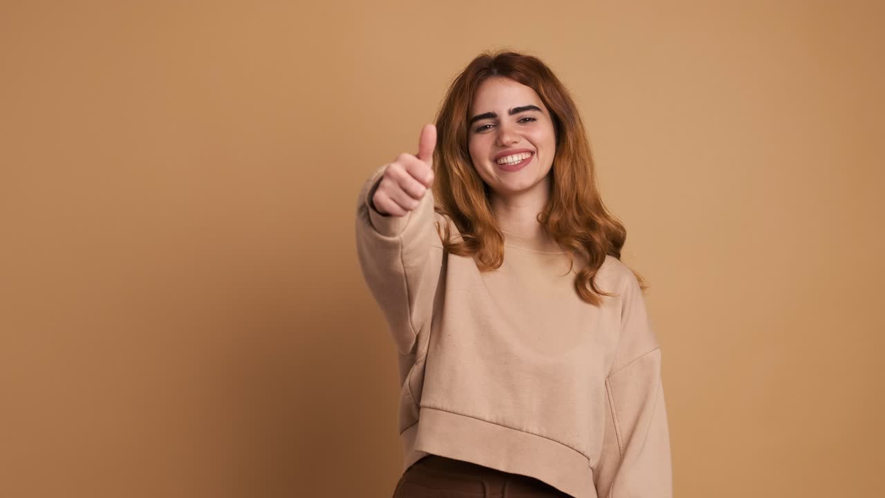 Happy young woman showing thumb up gesture