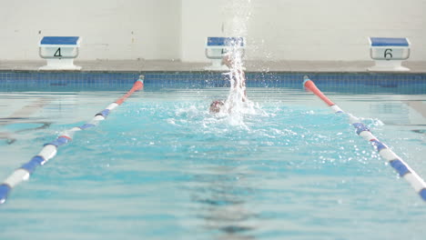 swimming in lane, athlete performing freestyle stroke in competition pool