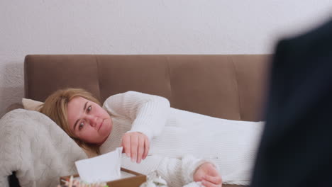 healing seeker lying on sofa in therapy session wiping tears with tissue while speaking to listening partner, warm indoor setting with cozy cushions creating supportive environment