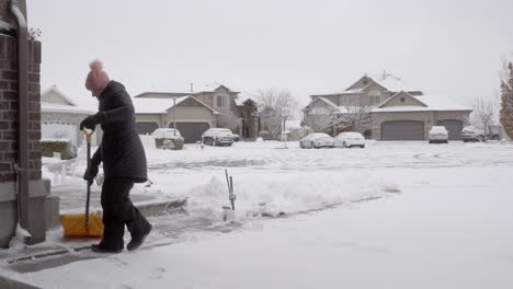 Senior-woman-shoveling-snow-in-her-driveway