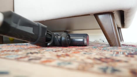 vacuuming under a sofa