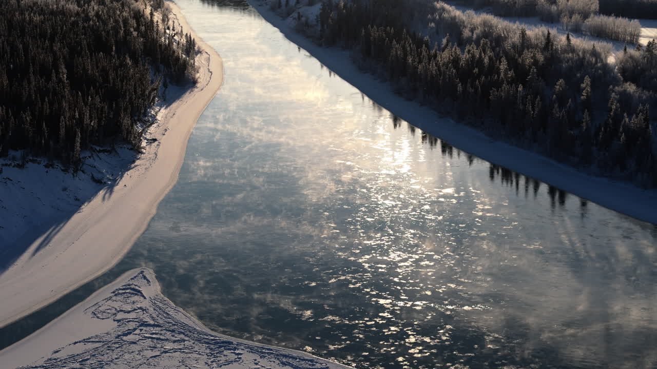 Fog Rising Over The Freezing Water Of Yukon River During Winter In Yukon, Canada. - aerial shot