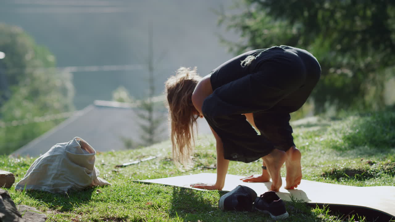 joven de pie sobre las manos en la postura de yoga en las montañas