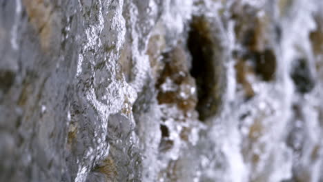 Vertical-of-a-clear-stream-running-through-stone-boulders-Abundant-river-flowing-in-slow-motion