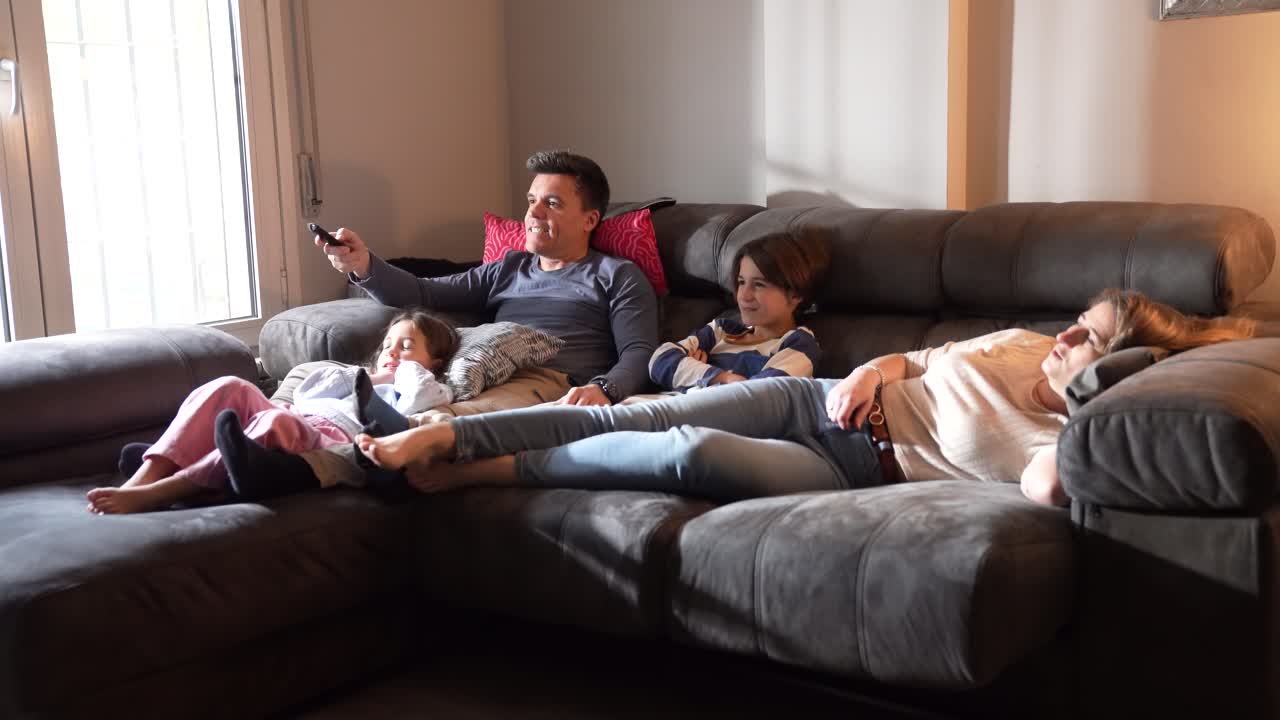 Family Relaxing and Watching TV on Sofa at Home