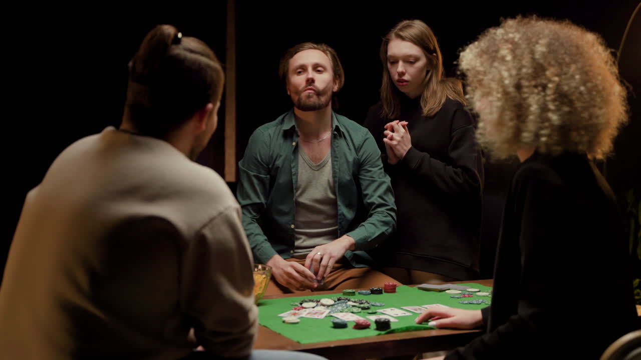 vista trasera de un grupo de amigos jugando al póquer sentados en sillas en una mesa 1