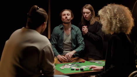 rear view of group of friends playing poker sitting on chairs at a table 1