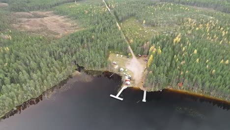 lake and dock surrounded by dense coniferous forest during autumn in sweden