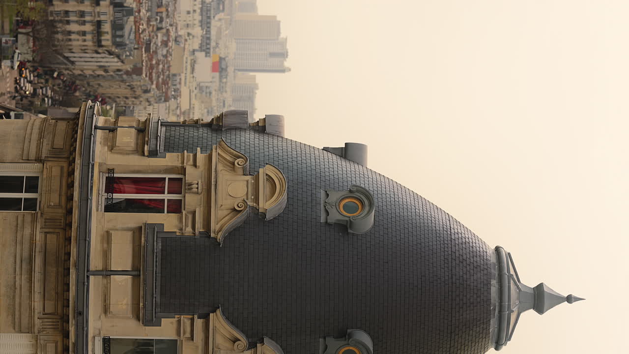Slow-motion vertical shot of a building's spire in downtown Paris, France