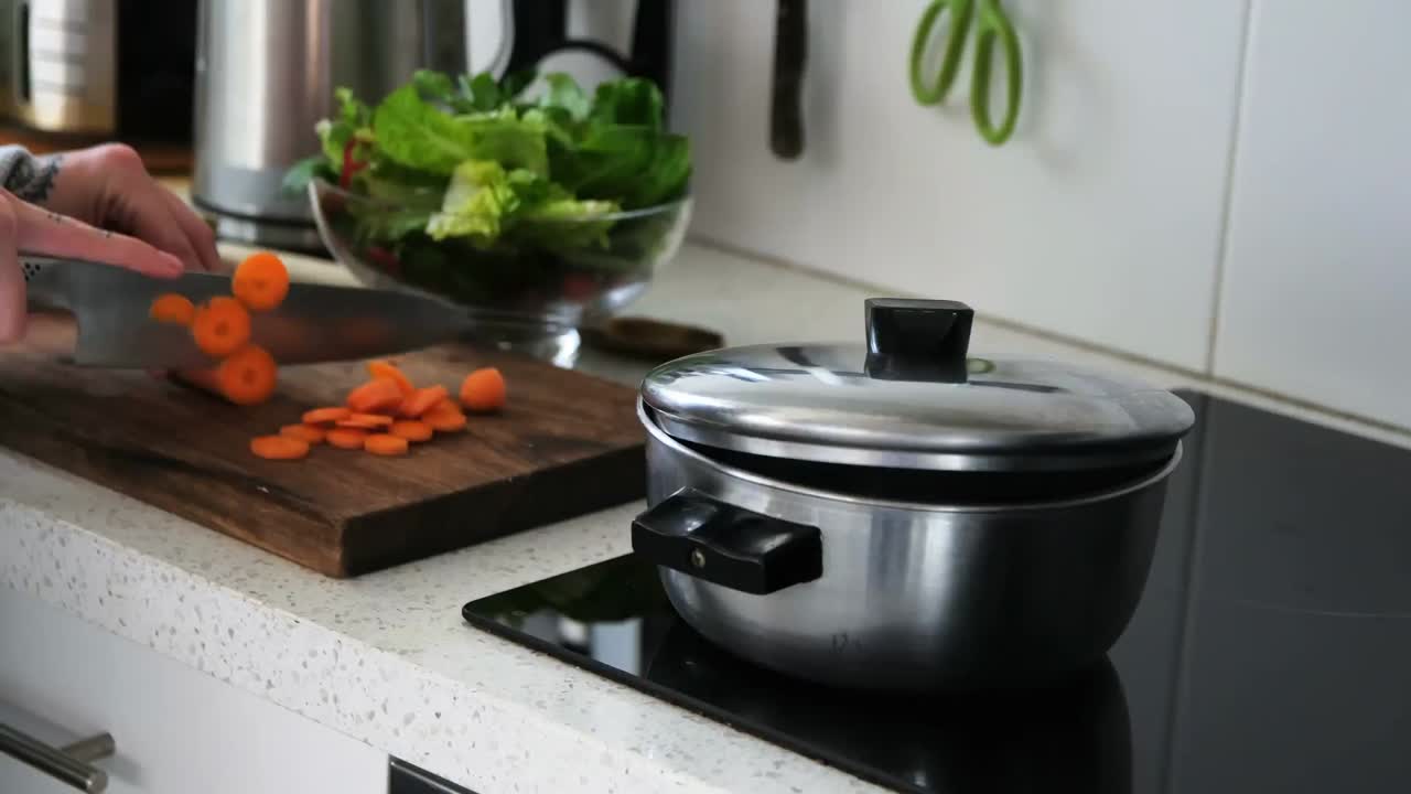 mujer cortando verduras en la cocina en casa 4k