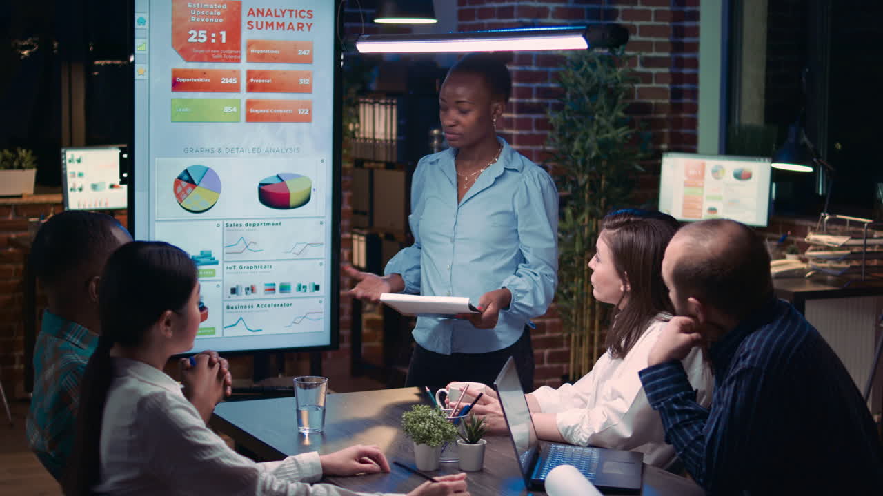 African american businesswoman speaking in business meeting, holding clipboard