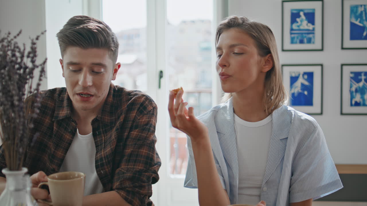 Newlyweds enjoying home breakfast closeup. Cheerful couple drinking coffee eat
