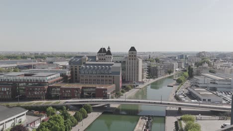 wide drone approach moving toward grands moulins de pantin and the canal in paris.