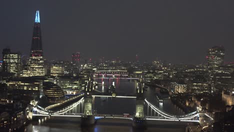 Langsam-Kreisende-Drohnenaufnahme-Der-Beleuchteten-Tower-Bridge-In-London-Bei-Nacht