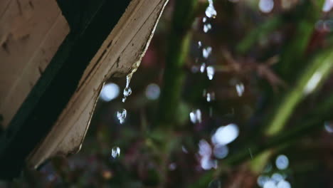 slow motion of raindrops dripping from metal roof