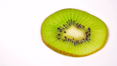 la rebanada de kiwi fresca está girando lentamente en el estudio con los detalles.
