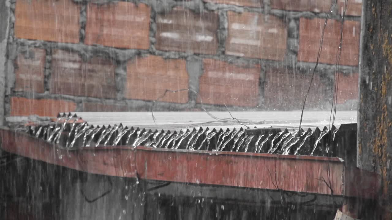 파동 된 강철 지붕 에 많은 비 가 내리고 있다