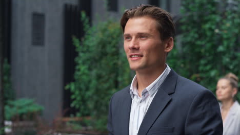 Smiling-businessman-walking-street-inspecting-busy-downtown-area-portrait.