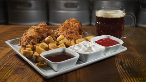 fried chicken tenders and home fries with a trio of dipping sauces paired with a dark lager, slider 4k