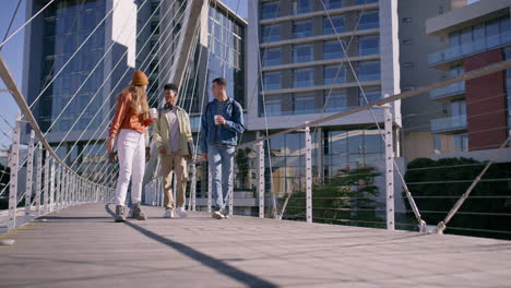 group of friends walking across a bridge in the city
