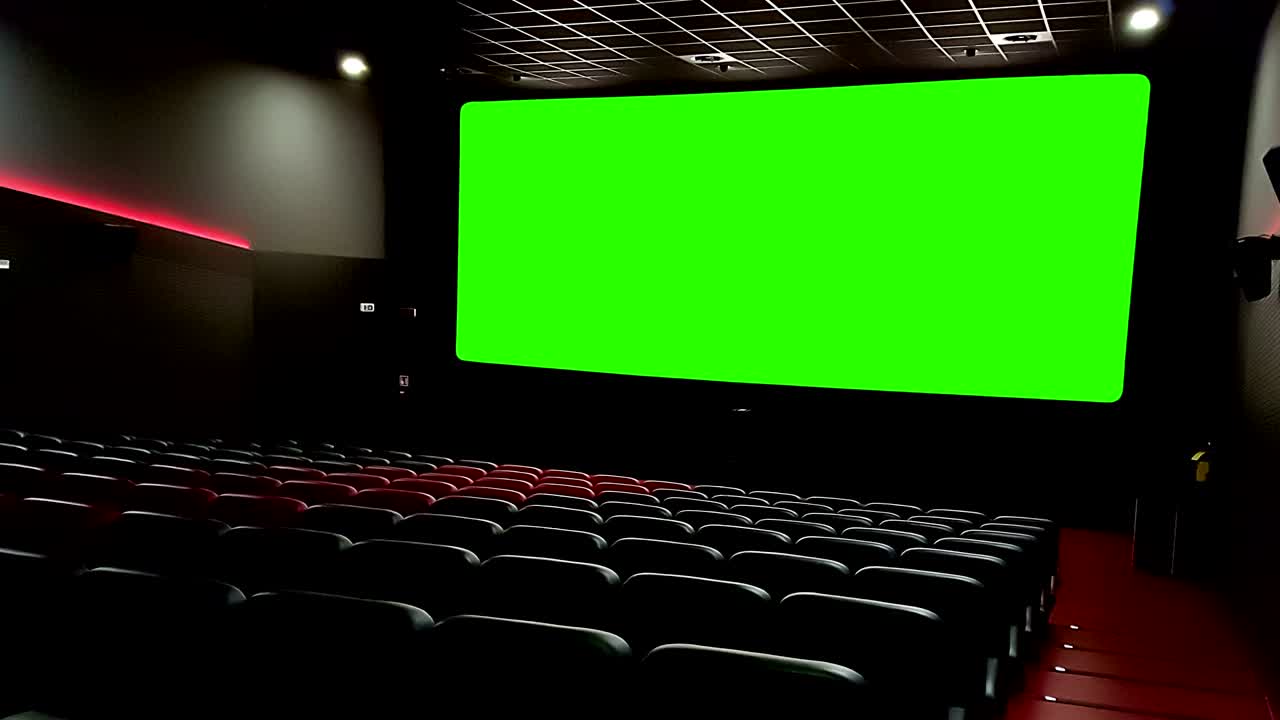 공허한 빨간 좌석과 함께 영화관 인테리어 크로마 키 녹색 스크린과 가장자리에 반이는 레크리에이션의 개념