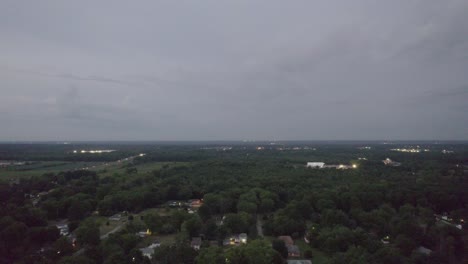 Luftdrohnen-Übersichtsaufnahme-Von-Baumwipfeln-Und-Häusern-Während-Der-Abendzeit-über-Einer-Kleinen-Stadt