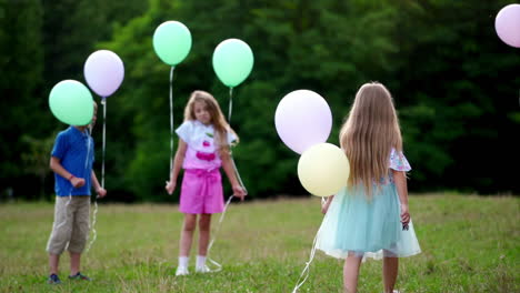 group of happy children playfully running with multicolored balloons
