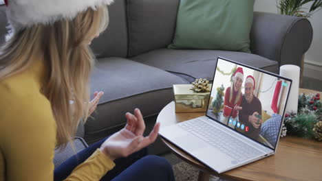 happy caucasian couple and female friend having christmas laptop video call, slow motion