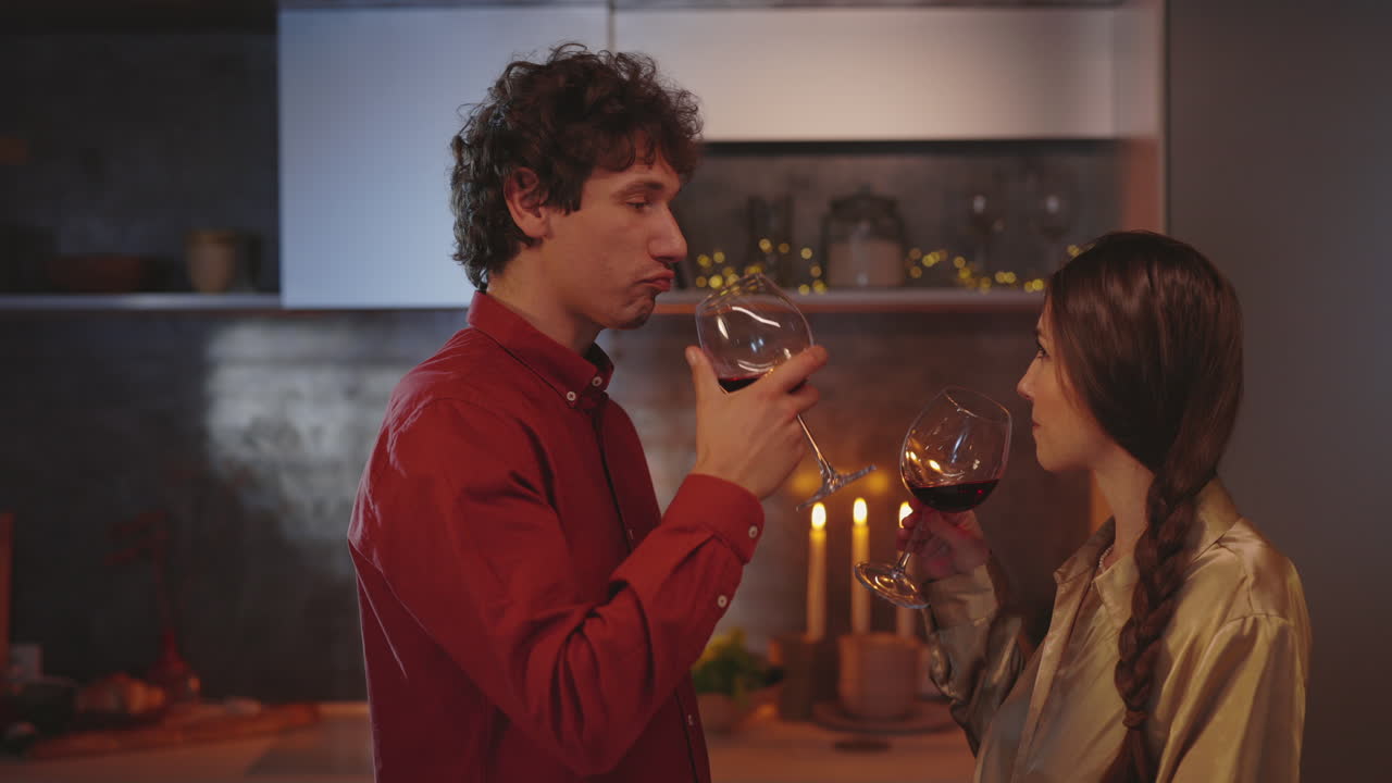 A couple enjoys a romantic evening with wine in their kitchen