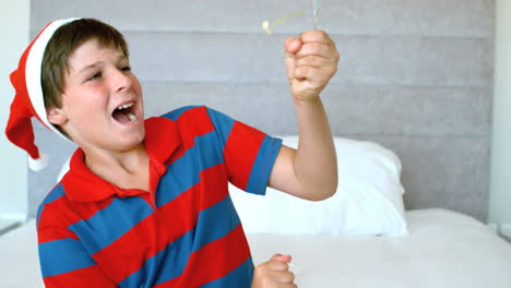 niño feliz usando popper de fiesta en el dormitorio