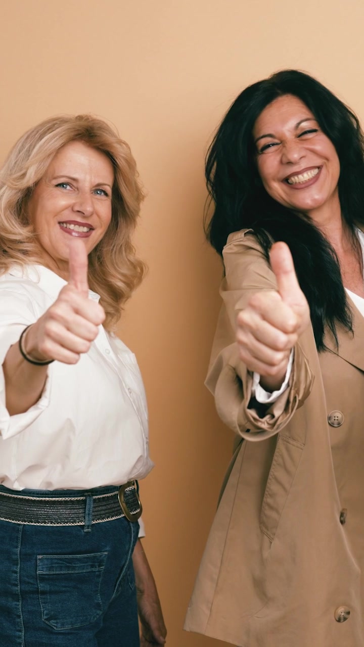 Two Happy Mature Women Giving Thumbs Up Gesture
