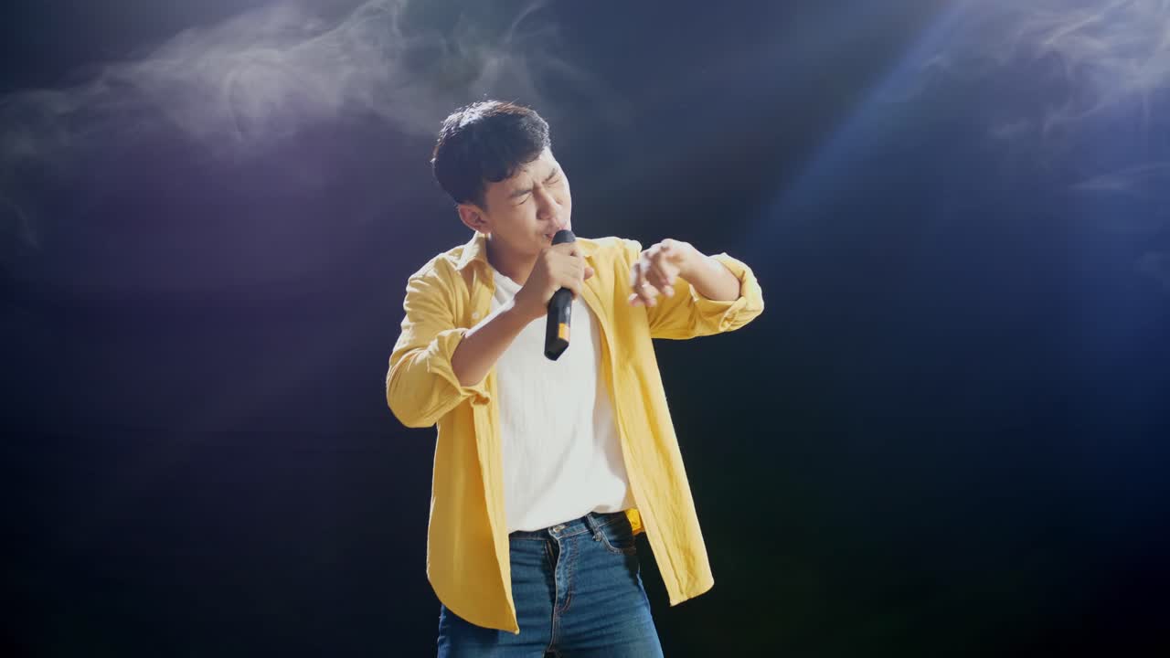 마이크 를 들고 무대에서 노래 하는 남자