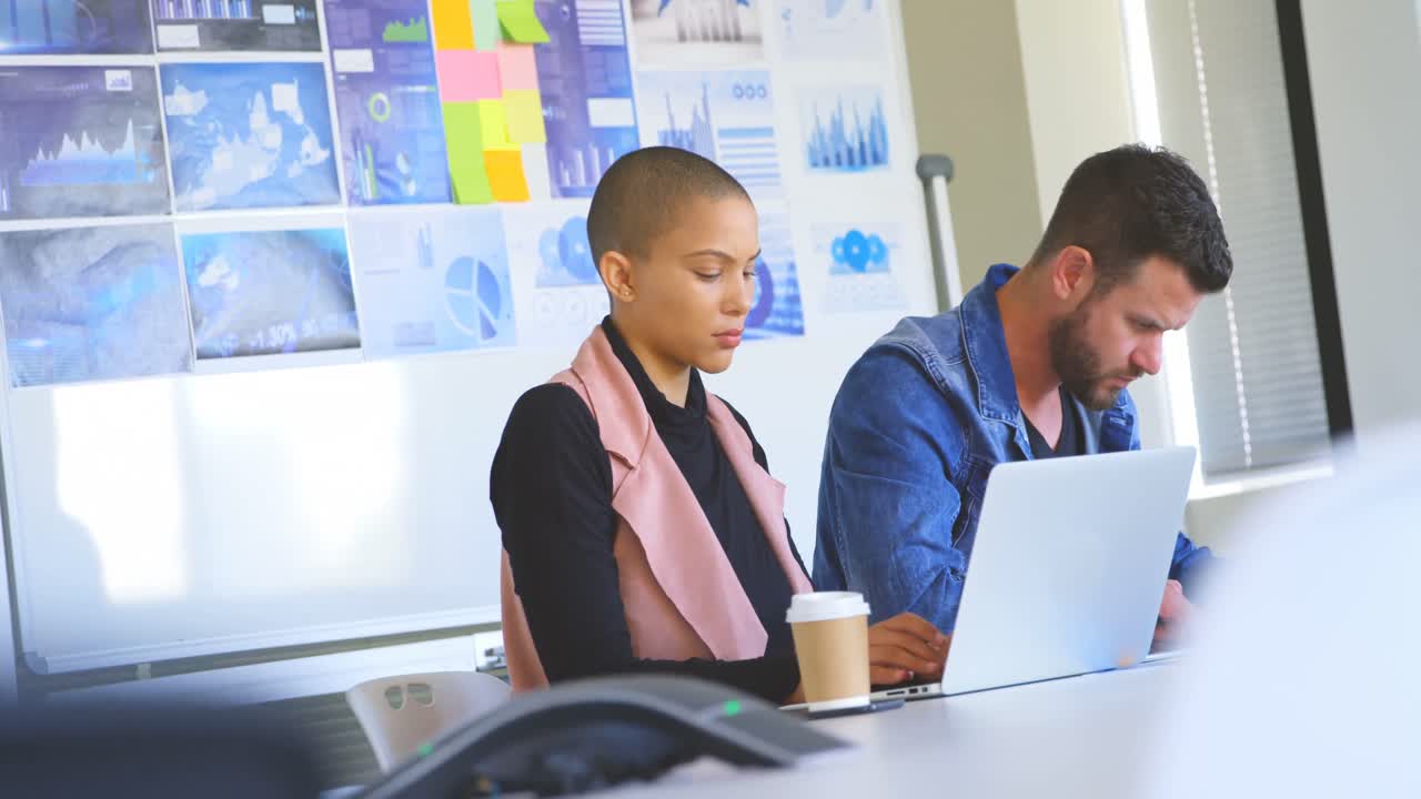 Young caucasian business colleagues working on laptop in modern office 4k
