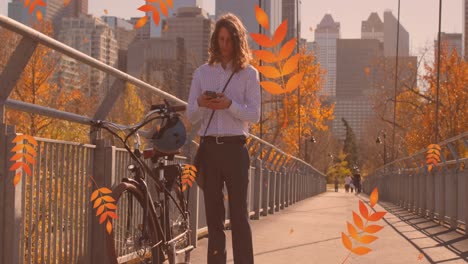 animation of autumn leaves falling over caucasian man with bike using smartphone